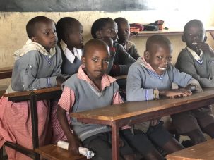Group of students sitting in an education setting at a desk.
