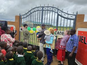 Ribbon cutting in front of a big gate for the new Hope Center.
